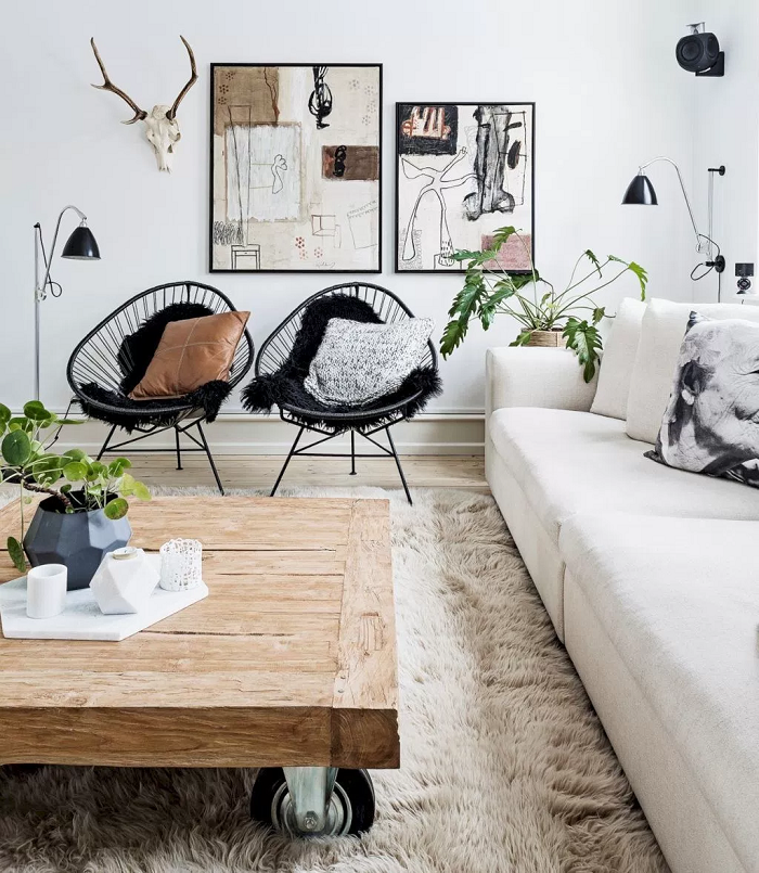 Scandinavian style living room with two acapulco black chairs with black sheepskin rugs and white neutral color palette