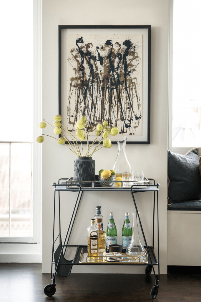 modern metal + glass masculine bar cart, professionally styled with bar essentials and a modern abstract wall art above bar cart