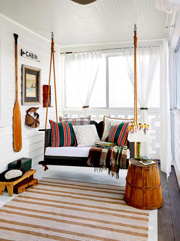 modern farmhouse porch decor with a swing sofa with vibrant boho cushions and rug.