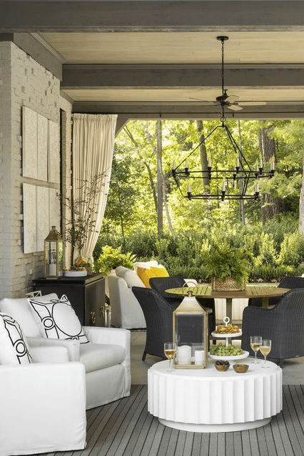 ront porch decorated with all four design layers — seating, string lights, potted plants, and a seasonal wreath on the door