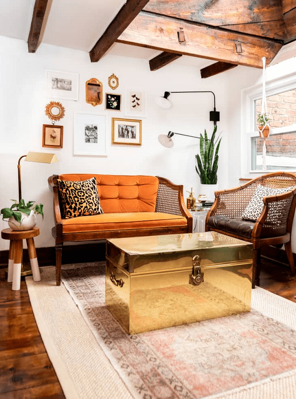 eclectic living room with a 10 piece bold wall art gallery wall and a swing arm wall sconce to ulliminate the wall art. 