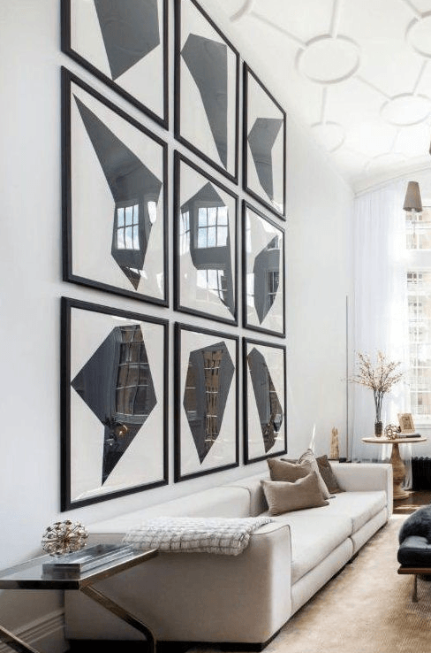a bachelor pad living room with oversize modern black and white shapets gallery wall.