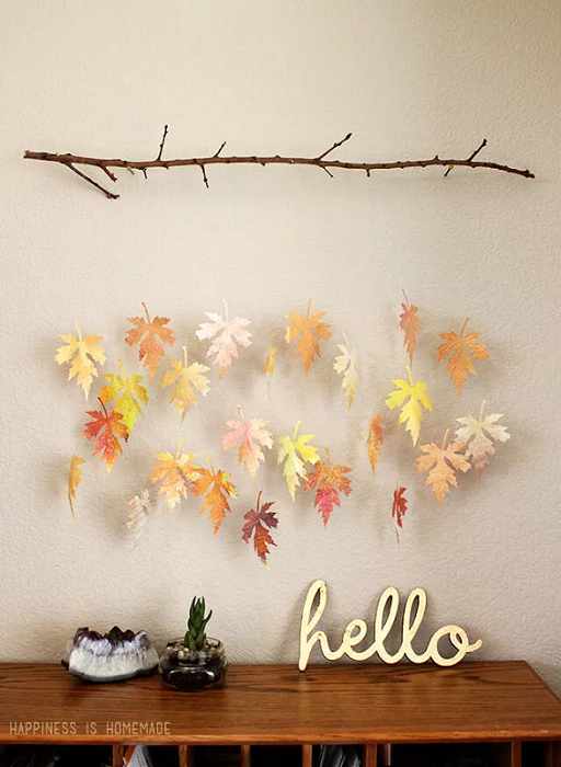 entryway accent wall with a light beige fall wall color and fall leaves hainging from ceiling for decorative purposes